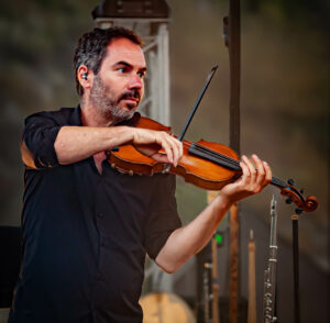 Sam sur scène jouant du violon
